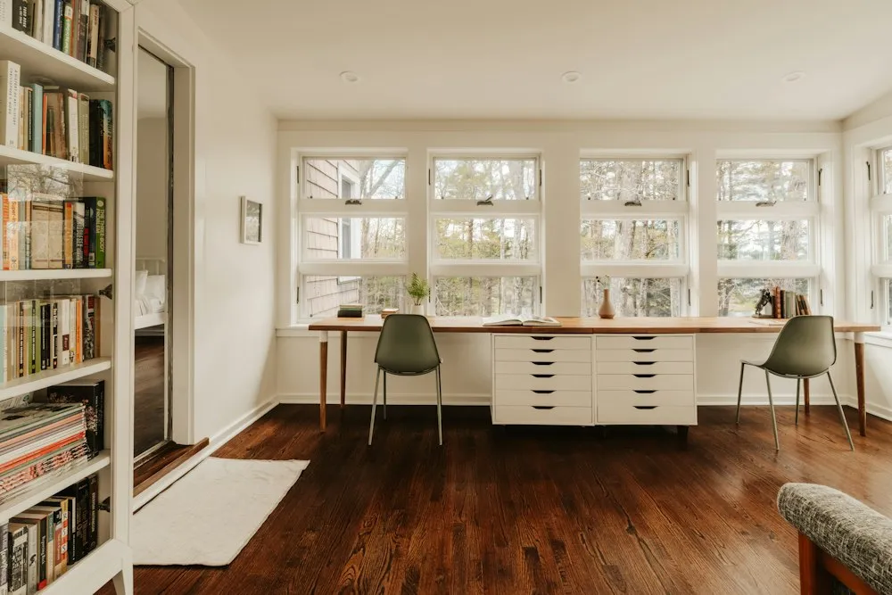 Home office com bancada longa e janelas